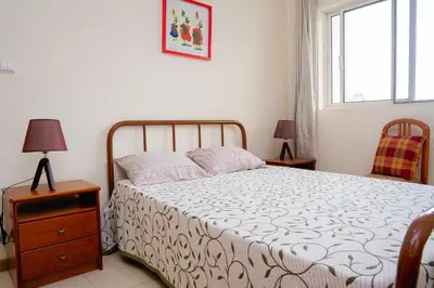 a bedroom with a bed and a dresser and a window at Bungavília house, Palmarejo in Praia