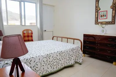 a bedroom with a bed and a dresser and a lamp at Bungavília house, Palmarejo in Praia