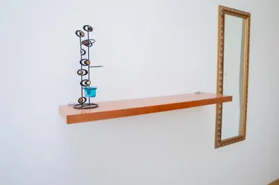 a wooden shelf with a candle holder and a mirror at Bungavília house, Palmarejo in Praia