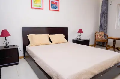 a bedroom with a large white bed and two lamps at Bungavília house, Palmarejo in Praia
