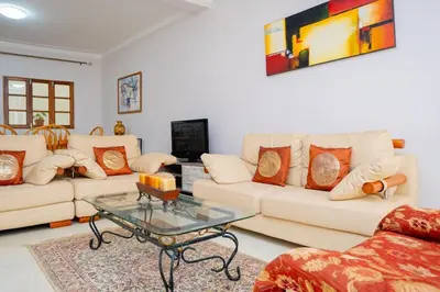 a living room with two couches and a coffee table at Bungavília house, Palmarejo in Praia