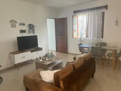 a living room with a couch and a table at Techas Stylish 2-Bedroom 8 min to Beach in Tarrafal