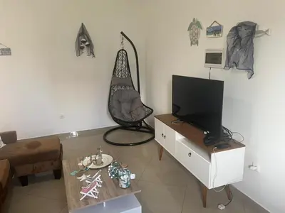 a living room with a television and a table at Techas Stylish 2-Bedroom 8 min to Beach in Tarrafal