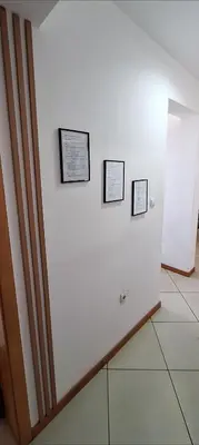 a white wall with three pictures on it at Sinta-se em casa! in Praia