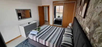 a living room with a bed and a mirror at Sinta-se em casa! in Praia