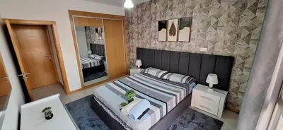a bedroom with a large bed and a mirror at Sinta-se em casa! in Praia