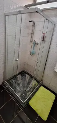 a shower stall with a green mat in a bathroom at Sinta-se em casa! in Praia