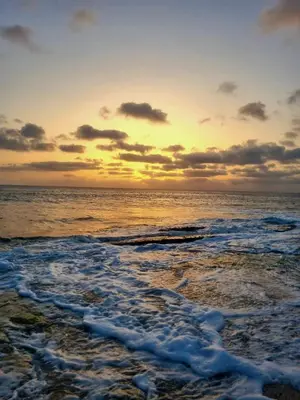 a sunset on the beach with the ocean at Bayview Bliss Appartement in Santa Maria