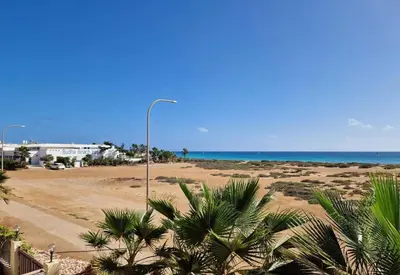 a street light and palm trees on a beach at Bayview Bliss Appartement in Santa Maria