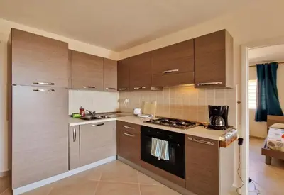 a kitchen with brown cabinets and a stove top oven at Bayview Bliss Appartement in Santa Maria