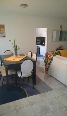 a dining table and chairs in a living room at Apartamento Mi in Praia