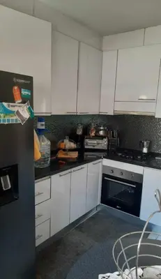 a kitchen with white cabinets and a stove top oven at Apartamento Mi in Praia