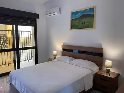 a bedroom with a large white bed and a window at Casa Nelly & Toi JB in Tarrafal