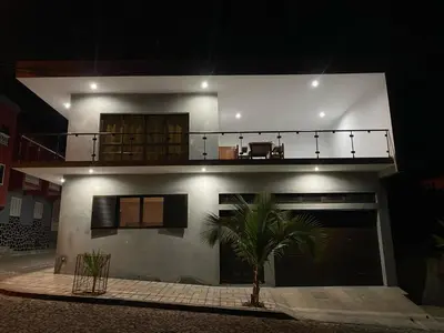 a house with a palm tree in front of it at night at Casa Nelly & Toi JB in Tarrafal