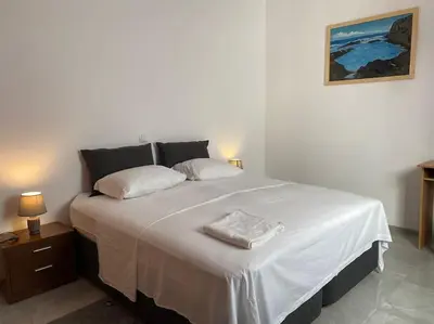 a bedroom with a large white bed with two pillows at Casa Nelly & Toi JB in Tarrafal