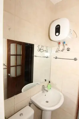 a bathroom with a sink and a toilet and a mirror at Kasa Tabuga in Porto Novo