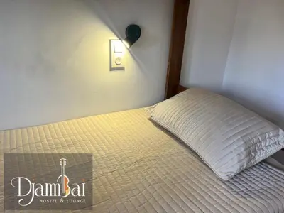 a bedroom with a bed with a pillow on it at Hostel Djambai in Mindelo