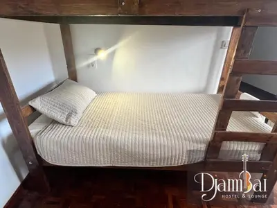 a small bed in a room with a ladder at Hostel Djambai in Mindelo