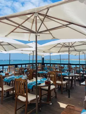 a restaurant with tables and chairs under umbrellas at Sal Little Heart Apartment 21 in Santa Maria