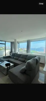a living room with a large couch and large windows at Casa Monte Cara T2 in Lazareto