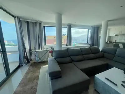 a living room with a couch and large windows at Casa Monte Cara T2 in Lazareto