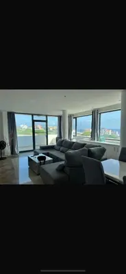 a living room with a large couch and windows at Casa Monte Cara T2 in Lazareto