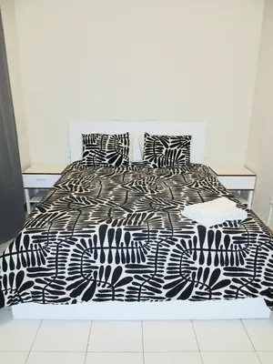a bed with a black and white comforter and pillows at Flat Mindelo Deluxe 30 in Mindelo