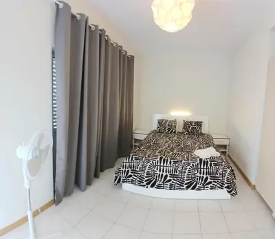 a bedroom with a bed with black and white sheets at Flat Mindelo Deluxe 30 in Mindelo
