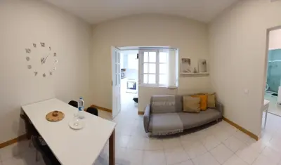 a living room with a couch and a table and a clock at Flat Mindelo Deluxe 30 in Mindelo