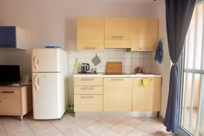 a kitchen with a white refrigerator and wooden cabinets at La Piazza in Santa Maria