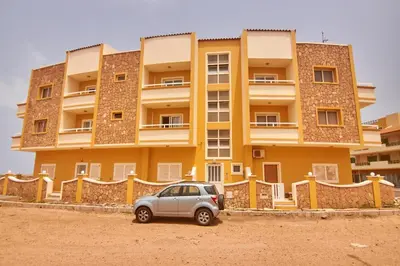 a car parked in front of a yellow building at La Piazza in Santa Maria