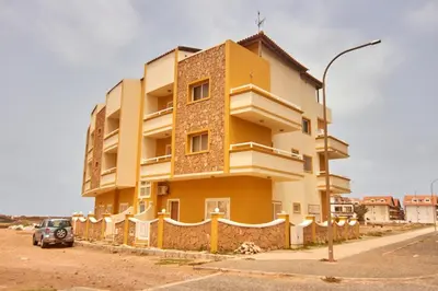 a yellow building with a car parked in front of it at La Piazza in Santa Maria