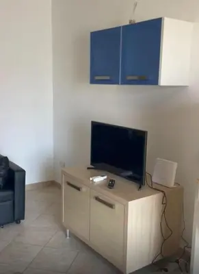 a living room with a flat screen tv on a table at Flor de Sal Apartment in Santa Maria