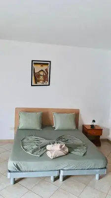 a bed with a doll laying on it in a room at Flor de Sal Apartment in Santa Maria