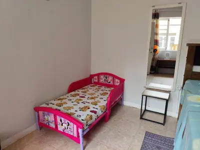 a small bedroom with a red bed in a room at Mendes Family Guesthouse, and Services in Praia