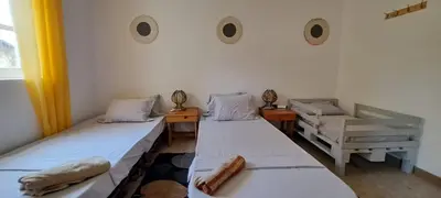a room with two beds and two chairs in it at Mendes Family Guesthouse, and Services in Praia