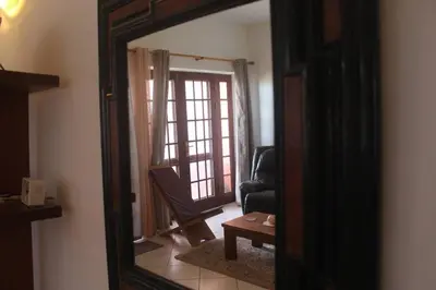 a mirror reflection of a living room with a chair at Casa Mar Doce in Sal Rei