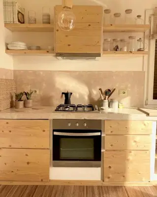 a kitchen with a stove and wooden cabinets at Casa da Leoa in Sal Rei