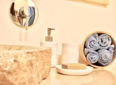 a bathroom with a sink and a bowl of towels at Casa da Leoa in Sal Rei