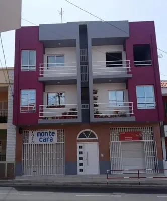 a red and white building with a parking garage at Elizabeth Rocha in Mindelo