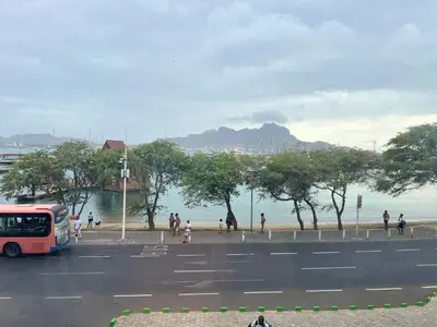 a bus parked on the side of a road near a beach at Apartamentos Baia Marginal 1 in Mindelo