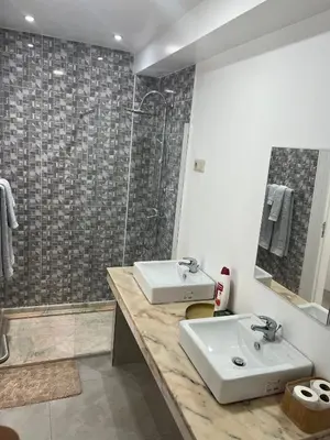 a bathroom with two sinks and a shower at Apartamentos Baia Marginal 1 in Mindelo
