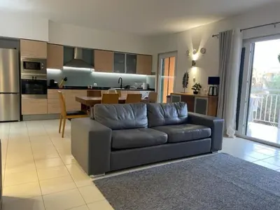 a living room with a couch and a kitchen at Cactus Gold Vila Verde in Santa Maria