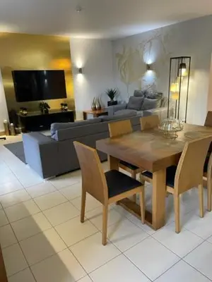 a living room with a table and a couch at Cactus Gold Vila Verde in Santa Maria