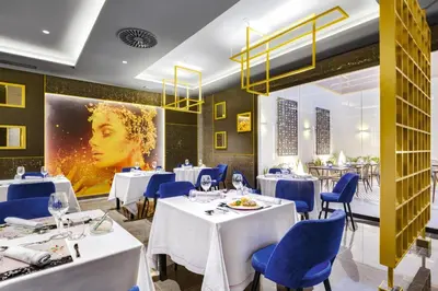 a restaurant with white tables and blue chairs at Hotel Riu Palace Santa Maria - All Inclusive in Santa Maria