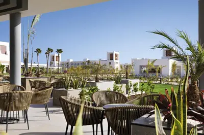 a patio with chairs and tables and buildings at Hotel Riu Palace Santa Maria - All Inclusive in Santa Maria