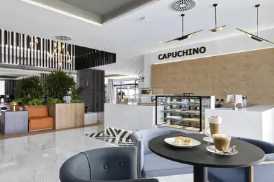a cafe with a table and chairs and a coffee shop at Hotel Riu Palace Santa Maria - All Inclusive in Santa Maria