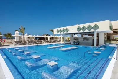 a pool at a resort with chairs and umbrellas at Hotel Riu Karamboa - Adults Only - All Inclusive in Rabil