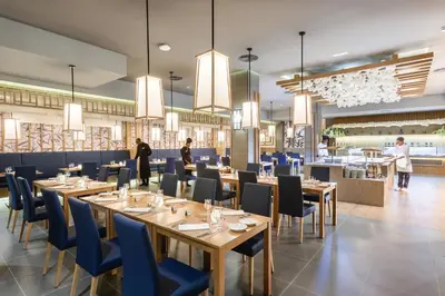 a restaurant with wooden tables and blue chairs at Hotel Riu Karamboa - Adults Only - All Inclusive in Rabil