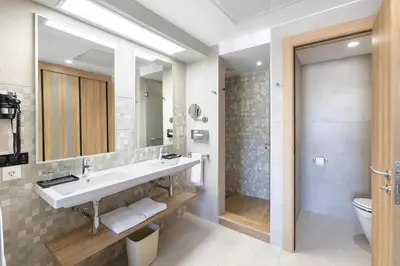 a bathroom with a sink and a toilet and a mirror at Hotel Riu Karamboa - Adults Only - All Inclusive in Rabil